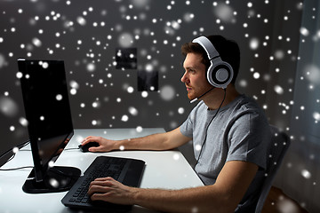 Image showing man in headset playing computer video game at home