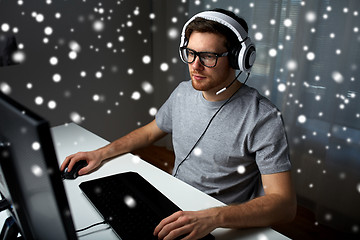 Image showing man in headset playing computer video game at home