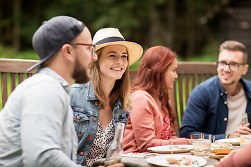 Image showing happy friends having dinner at summer garden party