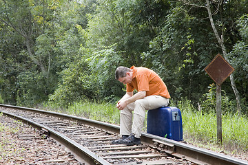 Image showing Man sitting on railroad track