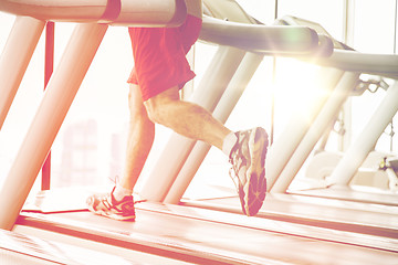 Image showing close up of male legs running on treadmill in gym