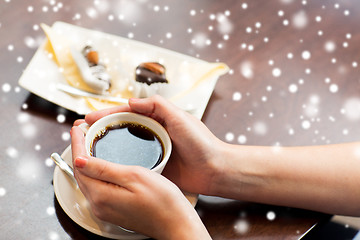 Image showing close up of woman holding coffee cup and dessert