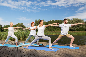 Image showing group of people making yoga exercises outdoors