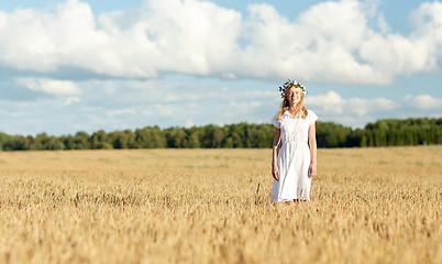 Image showing happy young woman in flower wreath on cereal field