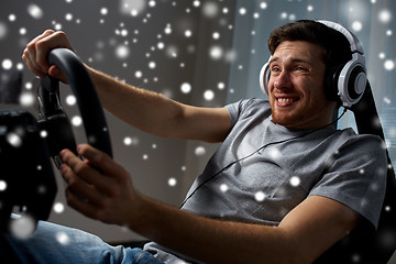 Image showing man playing car racing video game at home