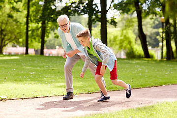 Image showing grandfather and grandson racing at summer park