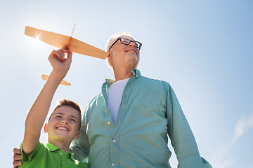 Image showing senior man and boy with toy airplane over sky