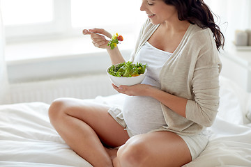 Image showing close up of pregnant woman eating salad at home