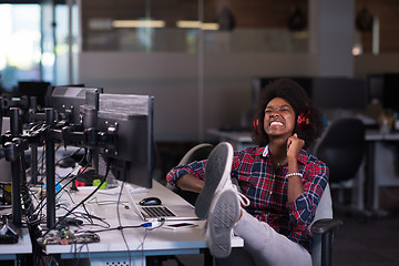 Image showing woman at her workplace in startup business office listening musi