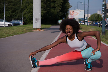 Image showing Portrait of sporty young african american woman stretching outdo