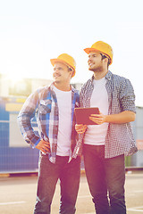 Image showing smiling builders with tablet pc outdoors