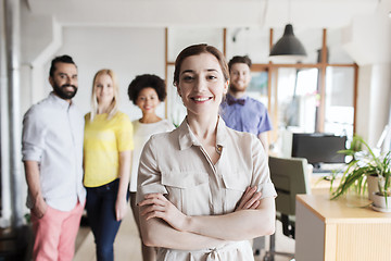 Image showing happy young woman over creative team in office