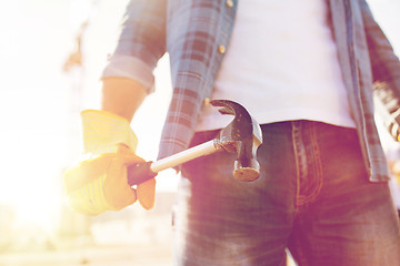 Image showing close up of builder hand in glove holding hammer