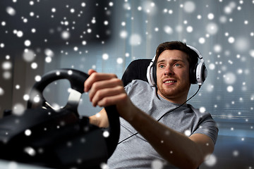 Image showing man playing car racing video game at home