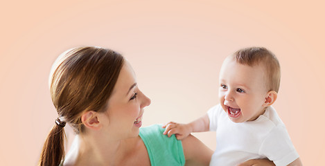 Image showing happy young mother with little baby over beige