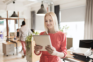 Image showing happy creative female office worker with tablet pc