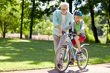 Image showing grandfather and boy with bicycle at summer park