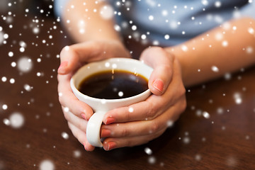 Image showing close up of woman holding hot black coffee cup