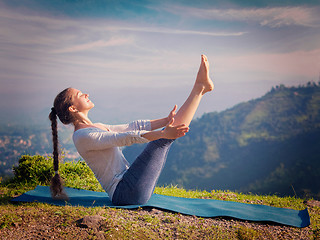 Image showing Woman doing Ashtanga Vinyasa Yoga asana Navasana - boat pose