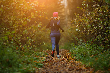 Image showing Blonde woman running among trees