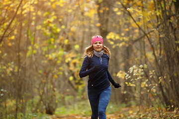 Image showing Woman running among autumn leaves