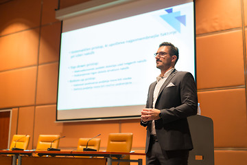 Image showing Speaker giving talk on podium at Business Conference.