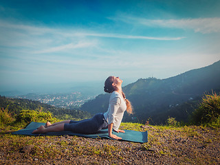 Image showing Woman practices yoga asana Urdhva Mukha Svanasana outdoors