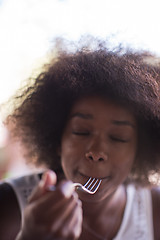 Image showing a young African American woman eating pasta