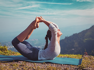 Image showing woman doing Ashtanga Vinyasa Yoga asana Dhanurasana - bow pose