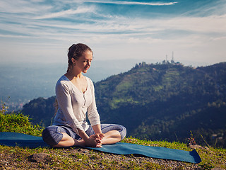 Image showing Sporty fit woman practices yoga asana Baddha Konasana outdoors