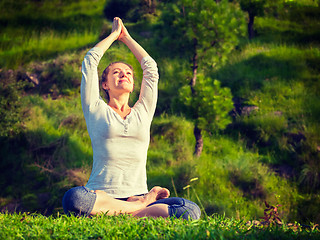 Image showing Young sporty fit woman doing yoga Lotus pose oudoors 