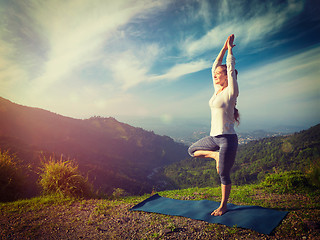 Image showing Woman in  yoga asana Vrikshasana tree pose in mountains outdoors