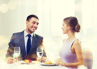 Image showing smiling couple eating main course at restaurant