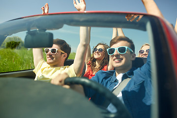 Image showing happy friends driving in cabriolet car at country