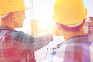 Image showing close up of builders with blueprint at building