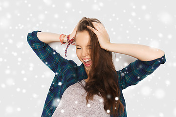Image showing happy teenage girl holding to head over snow