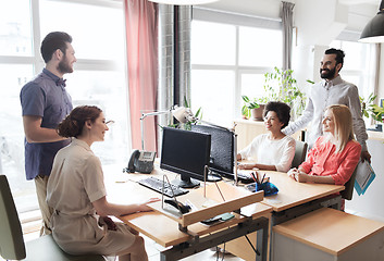 Image showing happy creative team talking in office