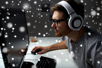 Image showing man in headset playing computer video game at home