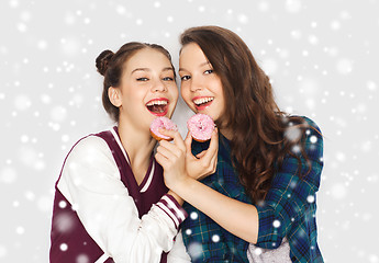 Image showing happy pretty teenage girls eating donuts