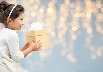 Image showing smiling little girl with gift box over lights