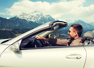 Image showing happy man driving cabriolet car over mountains