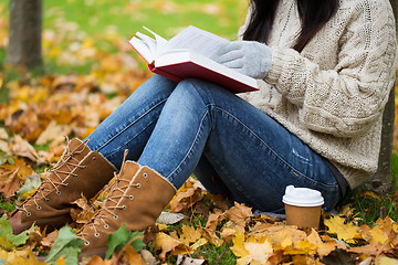 Image showing woman with book drinking coffee in autumn park