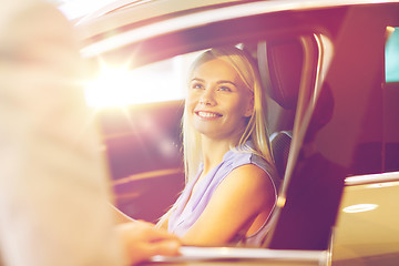 Image showing happy woman with car dealer in auto show or salon