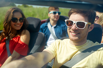 Image showing happy friends driving in cabriolet car