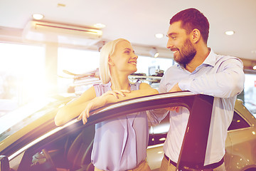 Image showing happy couple buying car in auto show or salon