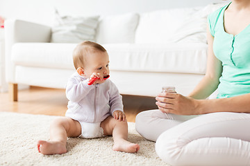 Image showing mother and baby with spoon eating puree at home