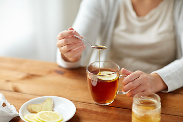 Image showing close up of ill woman drinking tea with lemon