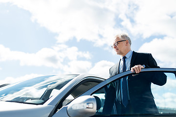 Image showing senior businessman getting into car