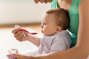 Image showing mother with spoon feeding little baby at home