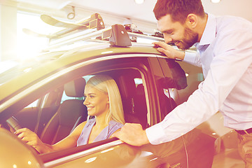 Image showing happy couple buying car in auto show or salon